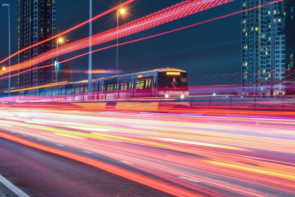 A speeding train in urban setting with streaking lights.
