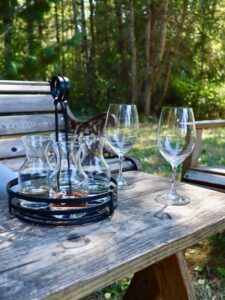 Wooden table in wooded area with tray of wine glasses
