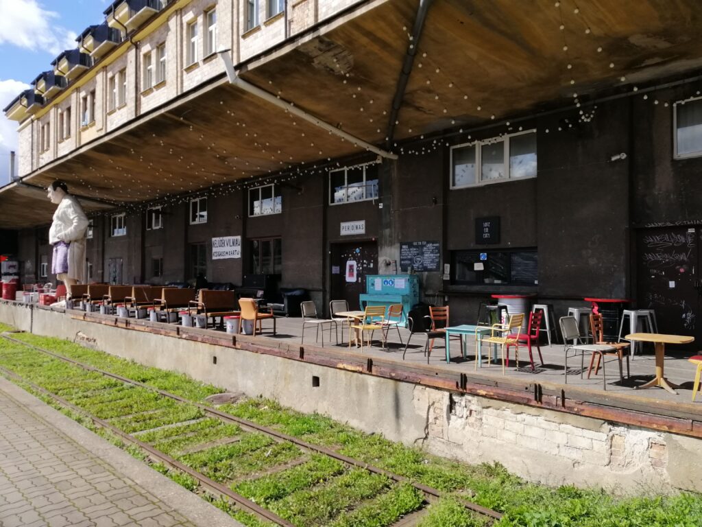 Cafe like seating on an old train platform with tracks running beneath