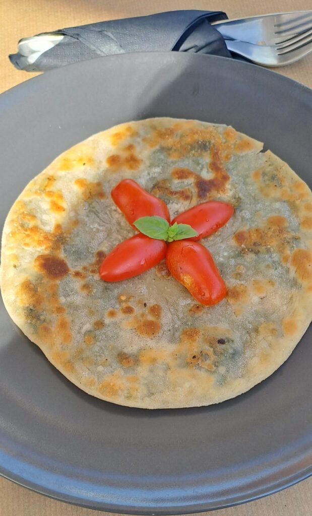 Pancake like dish with tomatoes on a plate