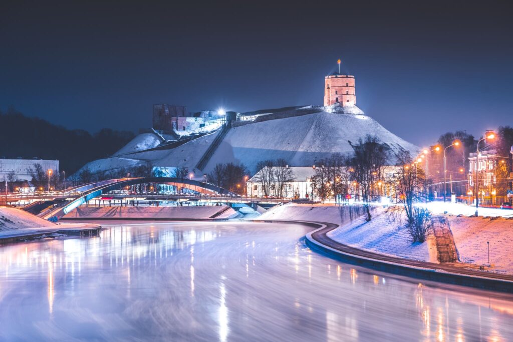Castle and tower atop a hill with river in icy landscape