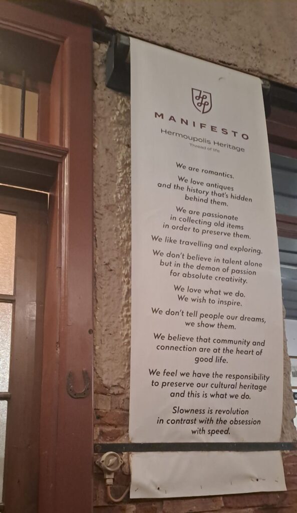 A sheet of paper hung on a building facade with a manifesto printed on it.