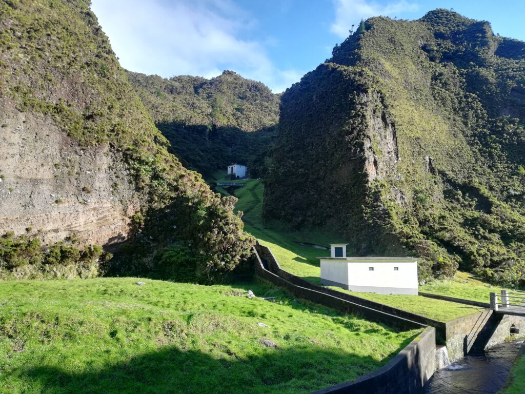 Small white buildings wedged between verdant mountains