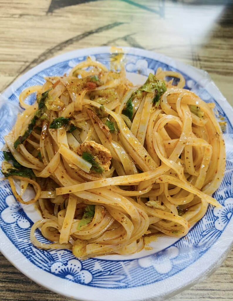 A plate of white noodles with seasoning