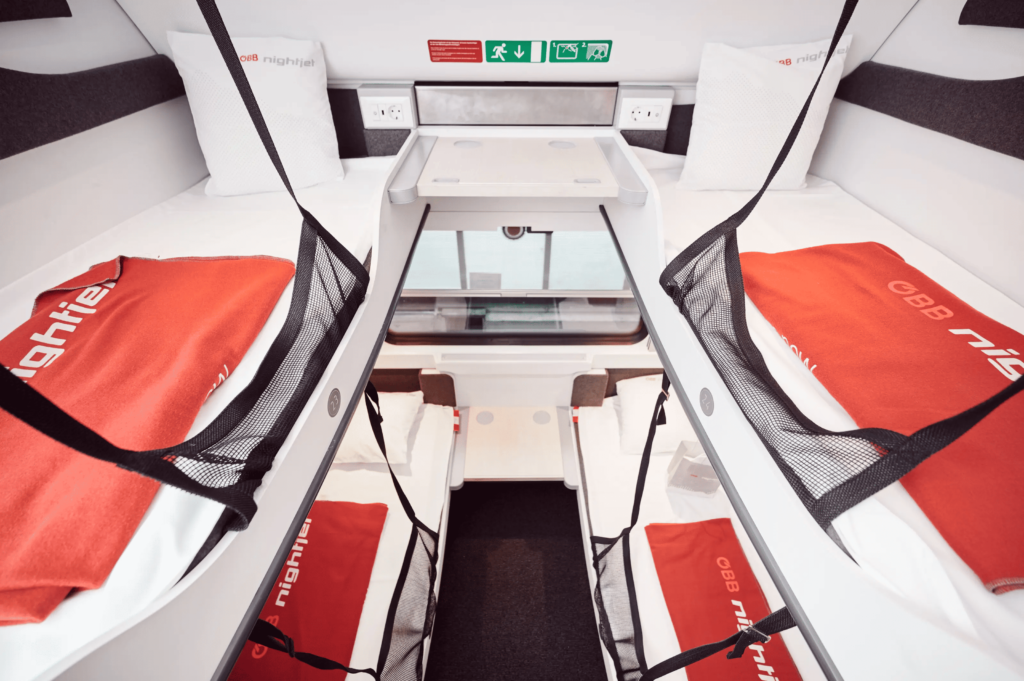 Sleeping compartment in train with four bunk beds.