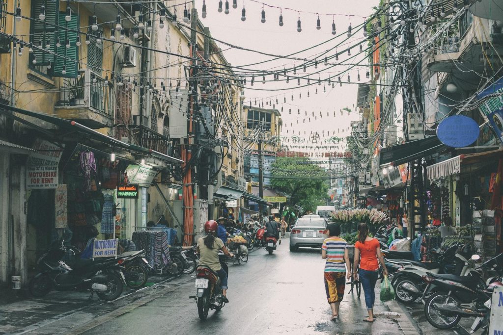 Street crisscrossed by electrical wires and jam packed by motorcycles.