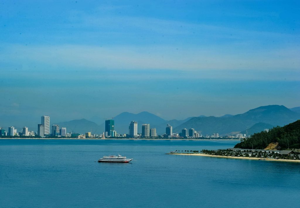City skyline seen across a bay with mountains in the background.