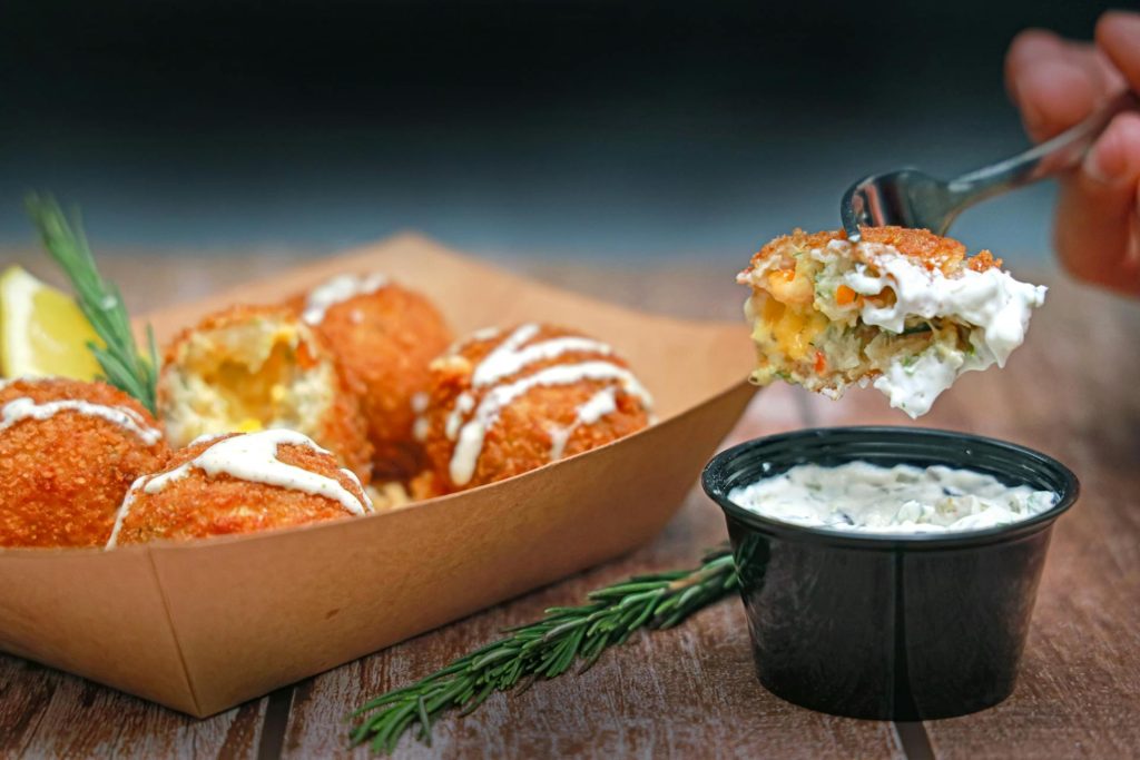 Serving of fried snacks and dipping sauce on a wooden table