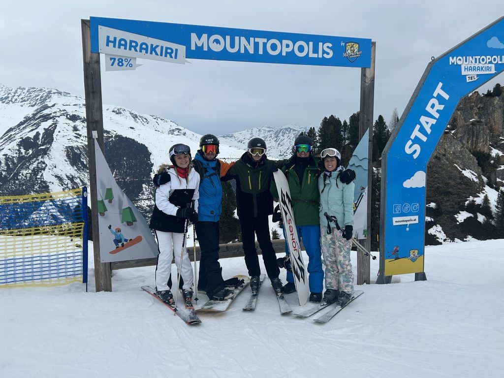 Group of skiers posing at the top of a slope
