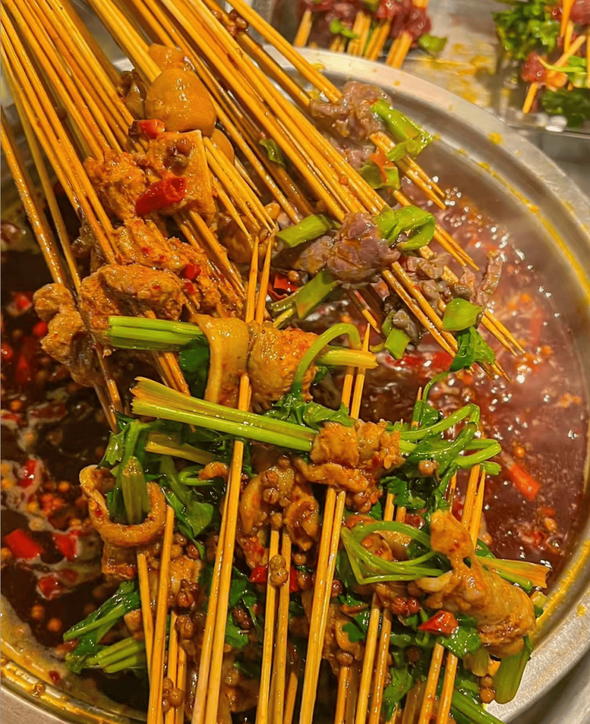 Meat and vegetable skewers in a boiling pot