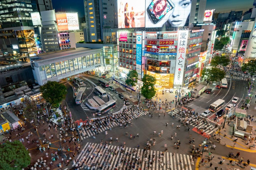 A large pedestrian crossing seen from above with large crowds crossing it.