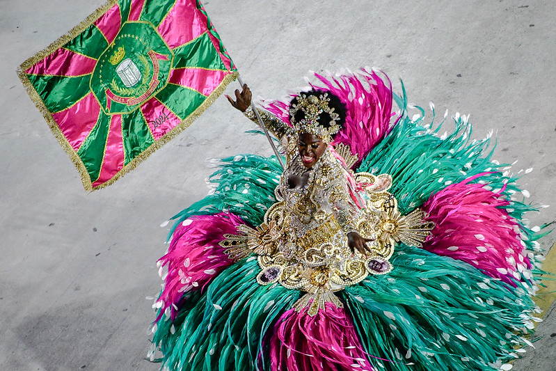 A woman in an elaborate dress holding a flag