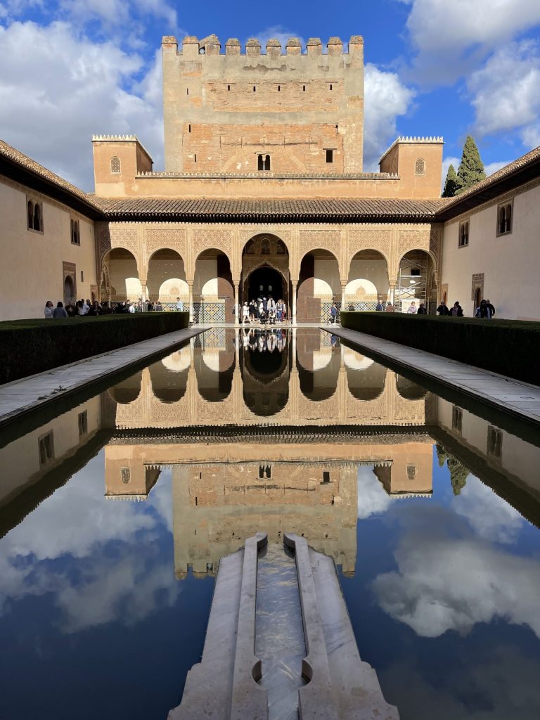 Courtyard inside a palace with pool of water reflecting the sky