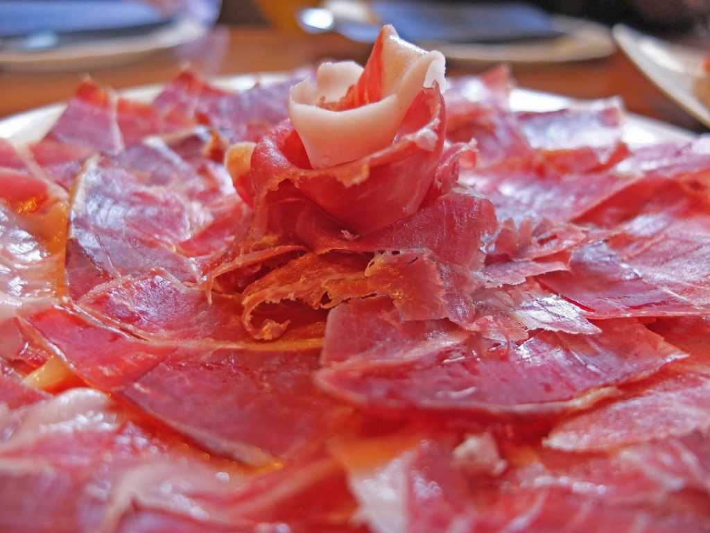 A plate of pink coloured jamon on a plate