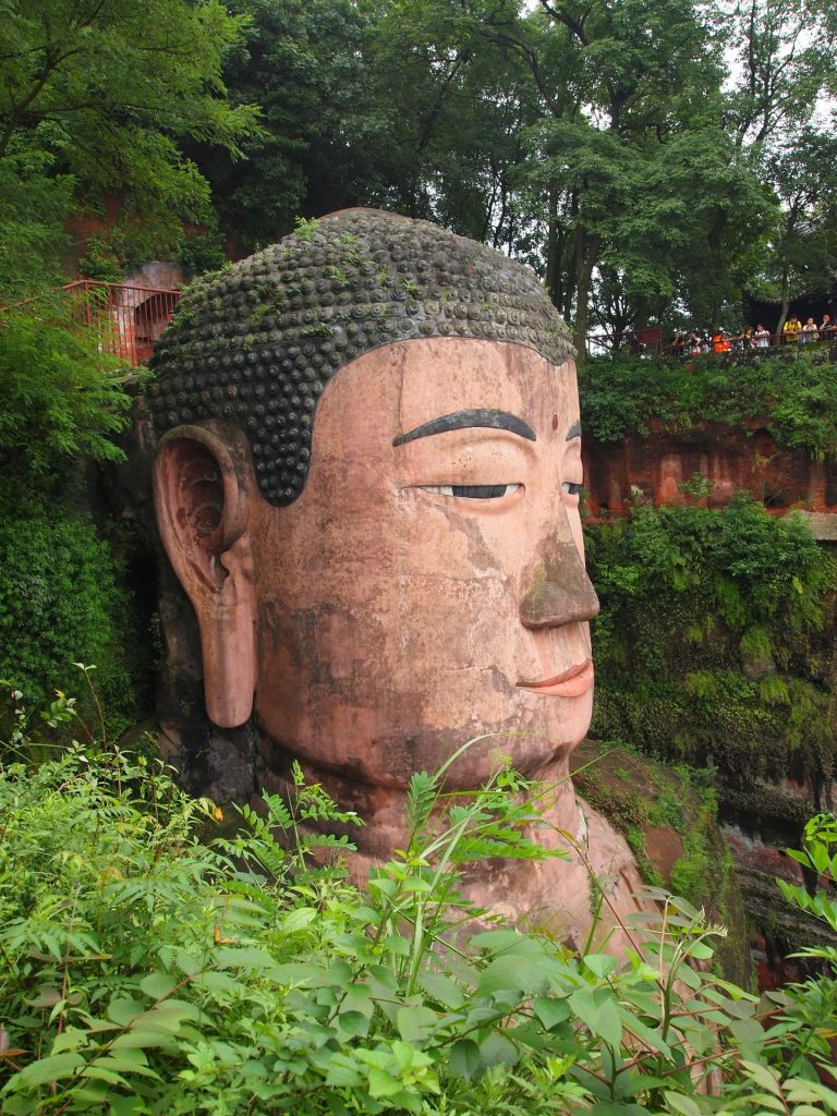 Giant statue of Buddha figure in forest setting