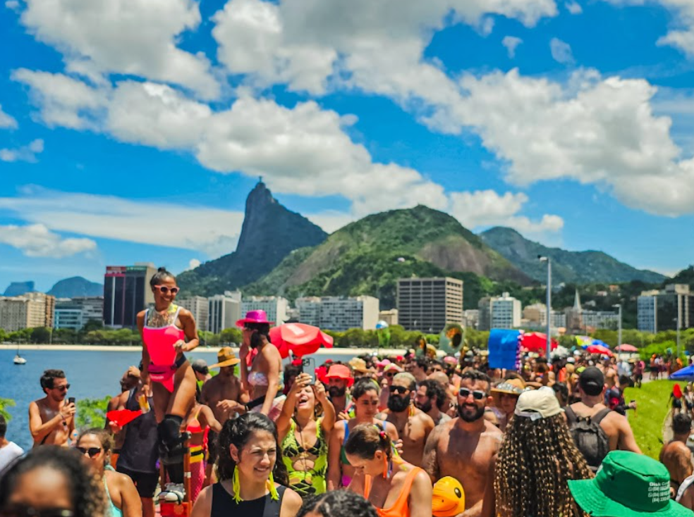 Parade of people celebrating on the beach with mountain in the background