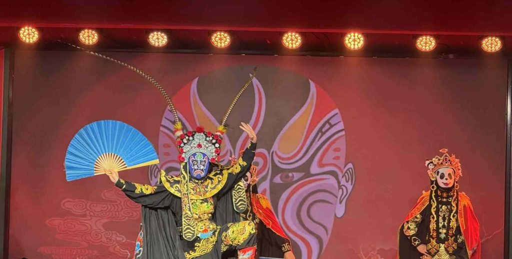 Stage performance with people in ornate costumers and masks