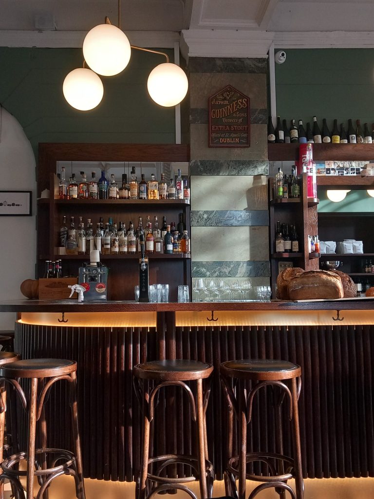 Barstools near a bar with drinks in background