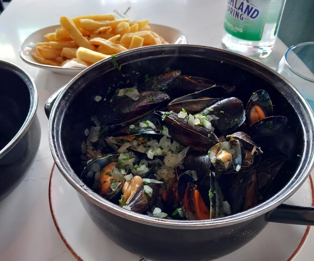 Pot of mussels marinière with side of fries