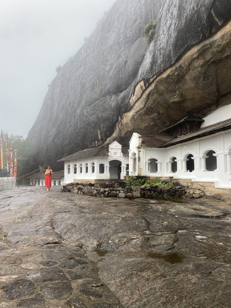 white temple building built into a cave