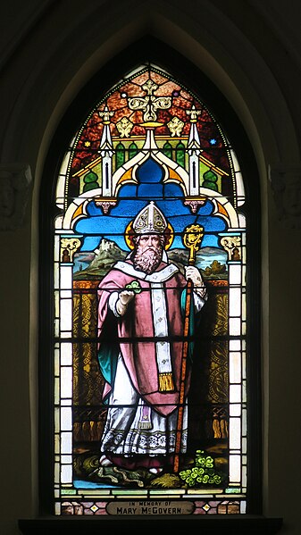 Stained glass window depicting St. Patrick with his crook and shamrock.