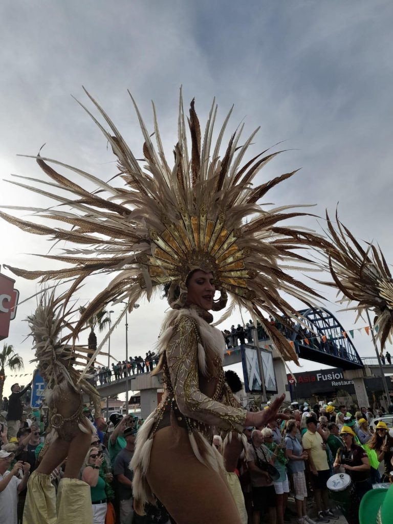 Woman in elaborate headdress with feathers in parade