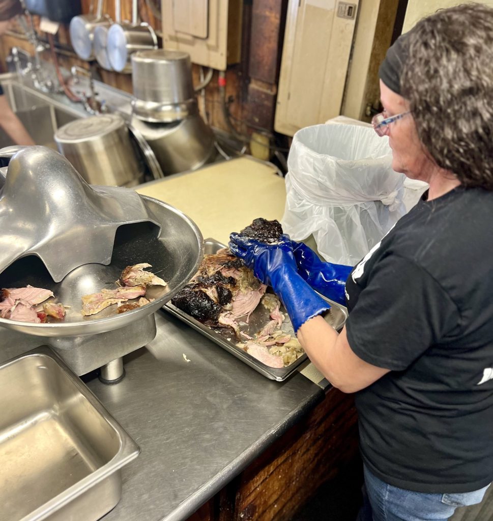 Woman in kitchen preparing meat