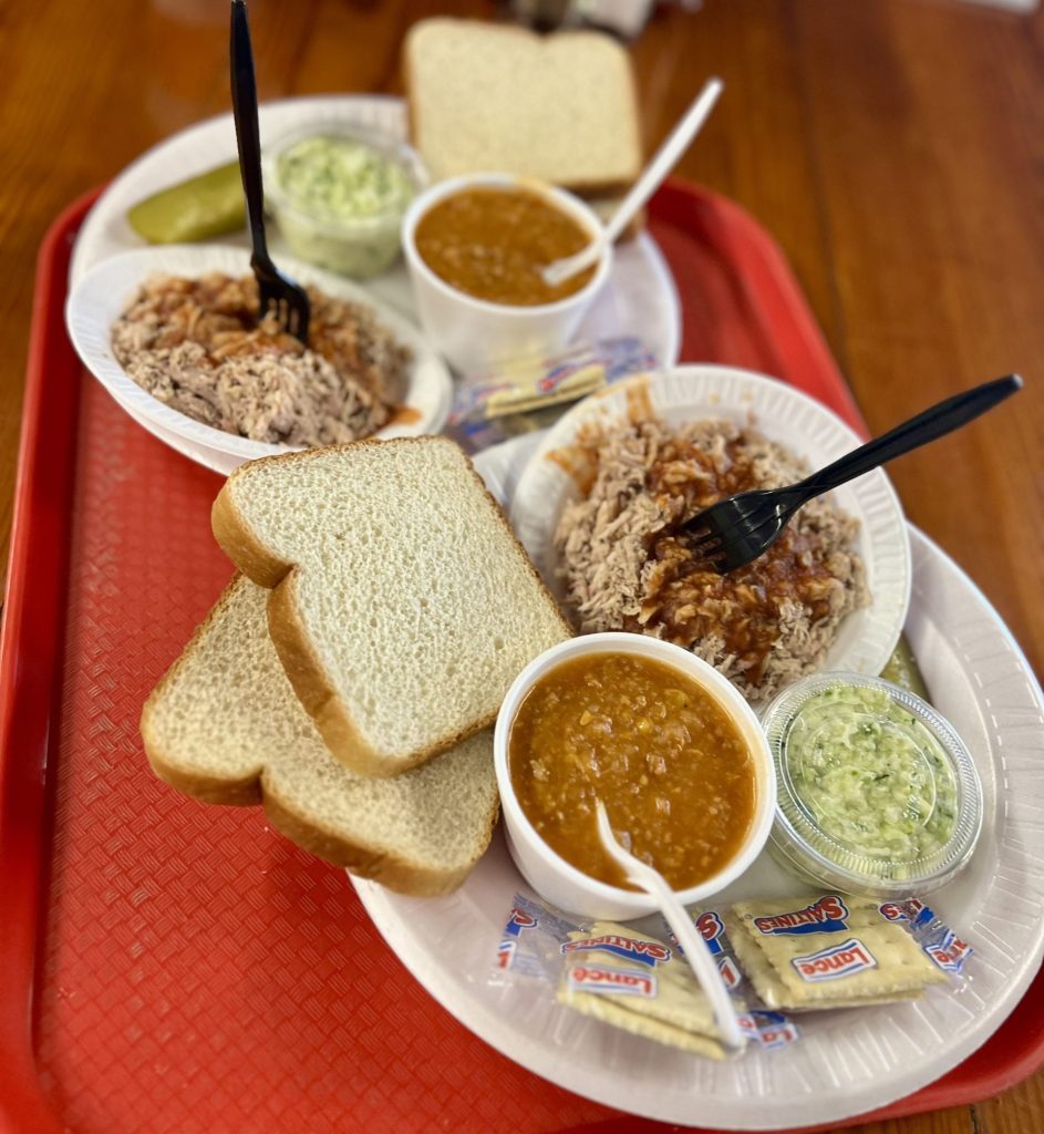 Red tray with plate of bread, barbecue meat and sauce