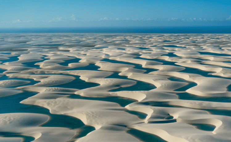 White sand dunes with pools of blue water in between