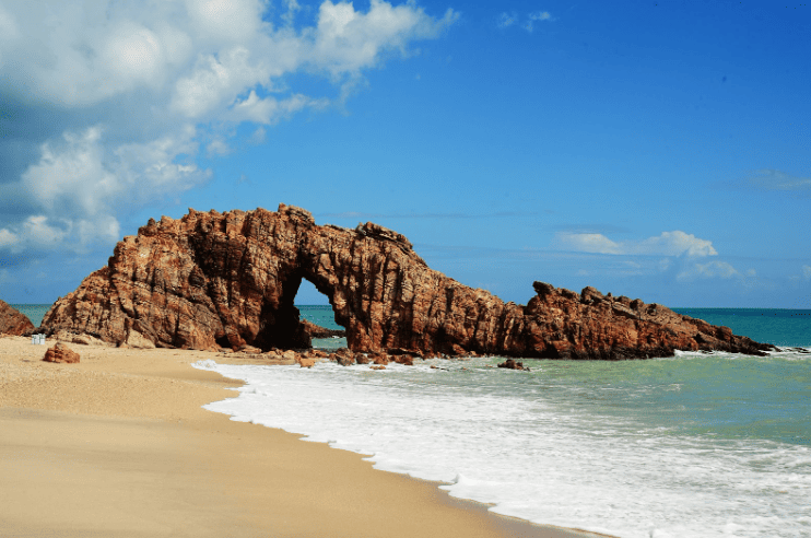 Beach with rock formation jutting out into the sea