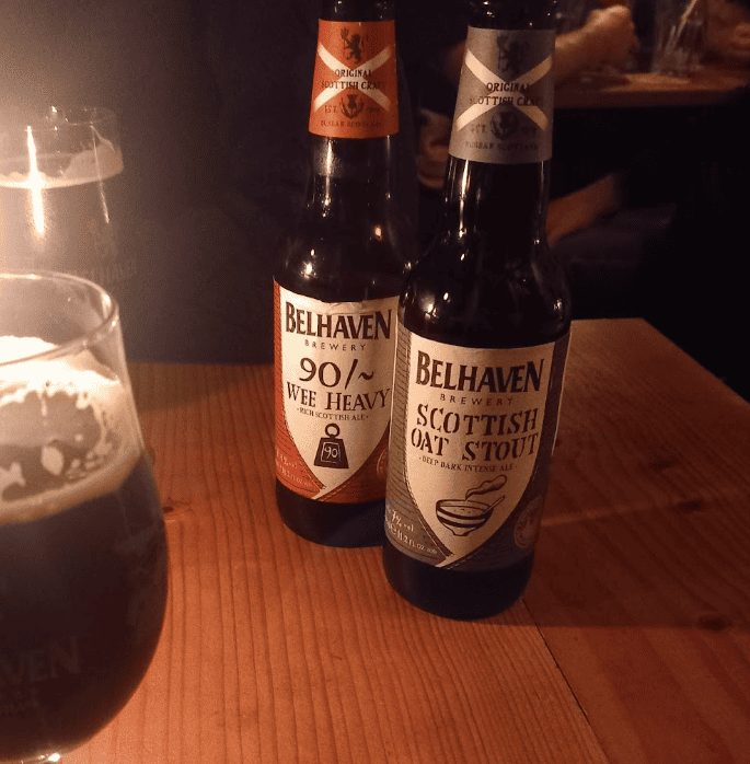Two bottles of beer on a table with a glass