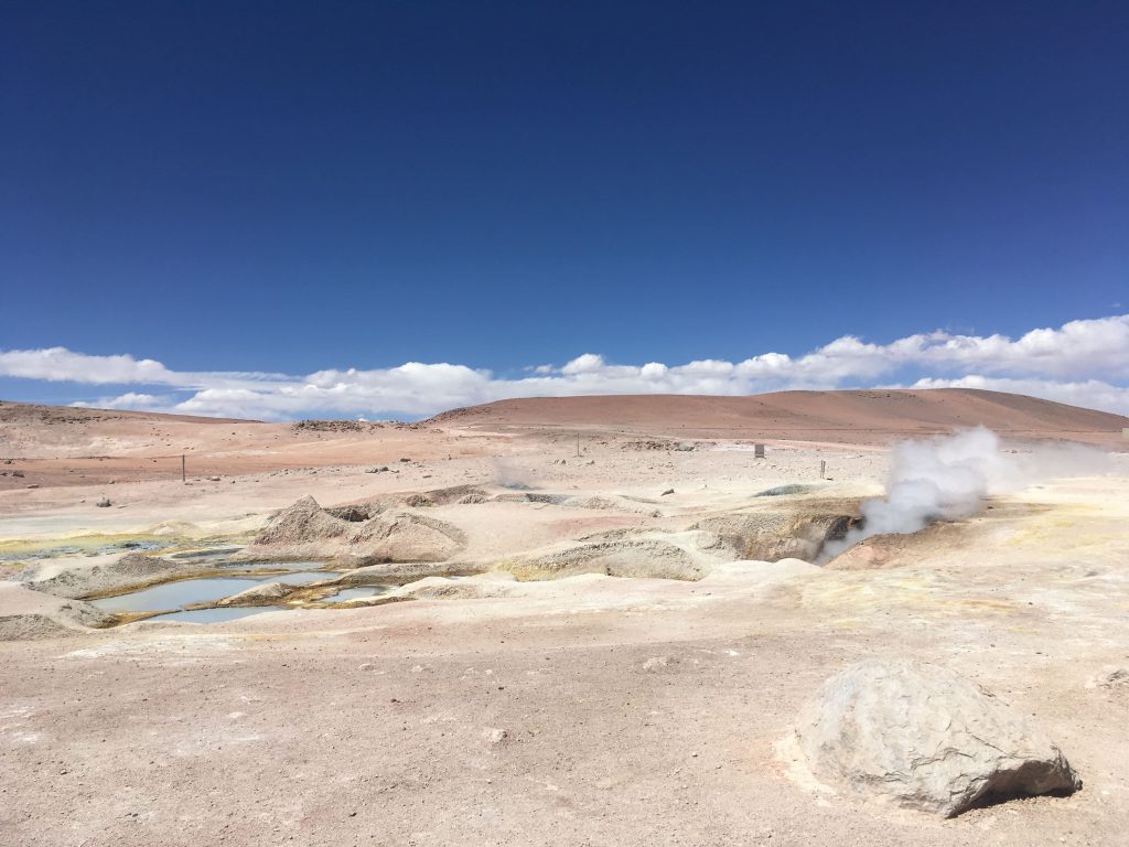 Small ponds and geysers in mountain landscape.