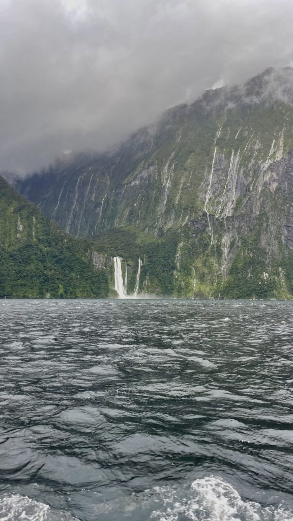 Multiple waterfalls cascading mountainside into fiord