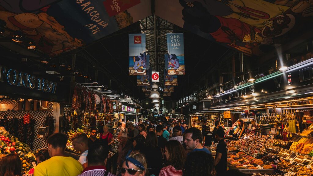 People crowding between food and market stalls inside