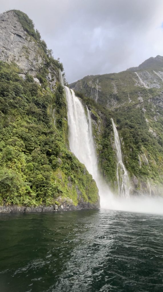 Waterfall amid green covered mountains