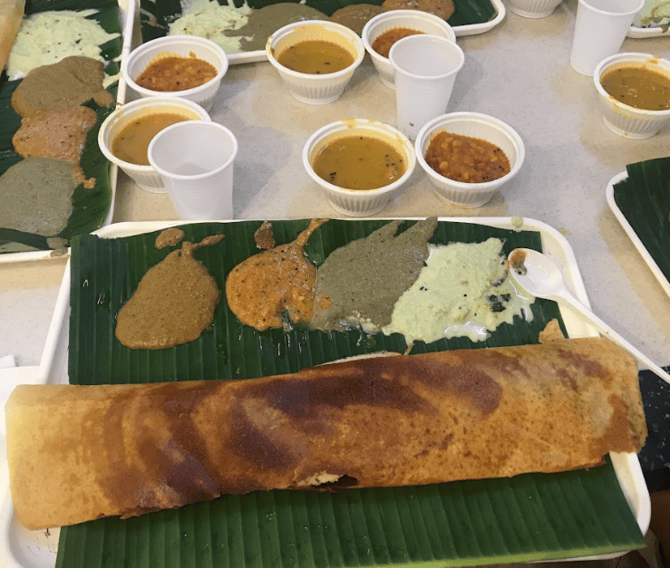 Table with trays of rolled pancake with dipping sauces