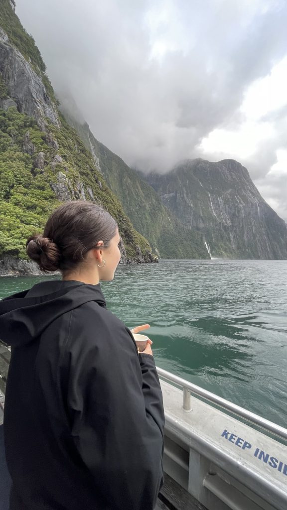 Woman on boat looking at fiord landscape