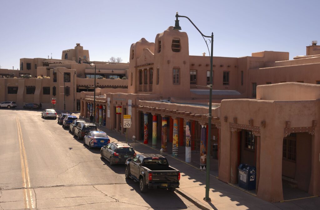 Red/brown buildings along a street with parked cars