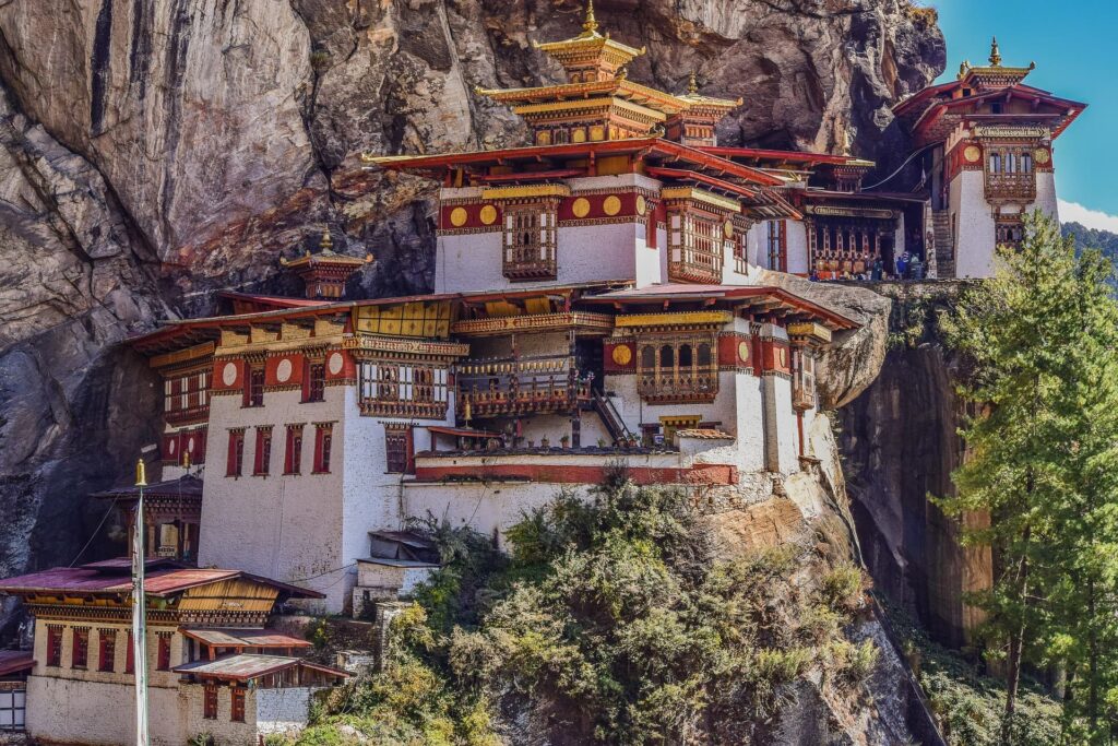 Red, gold, and white monastery perches on a mountain wall