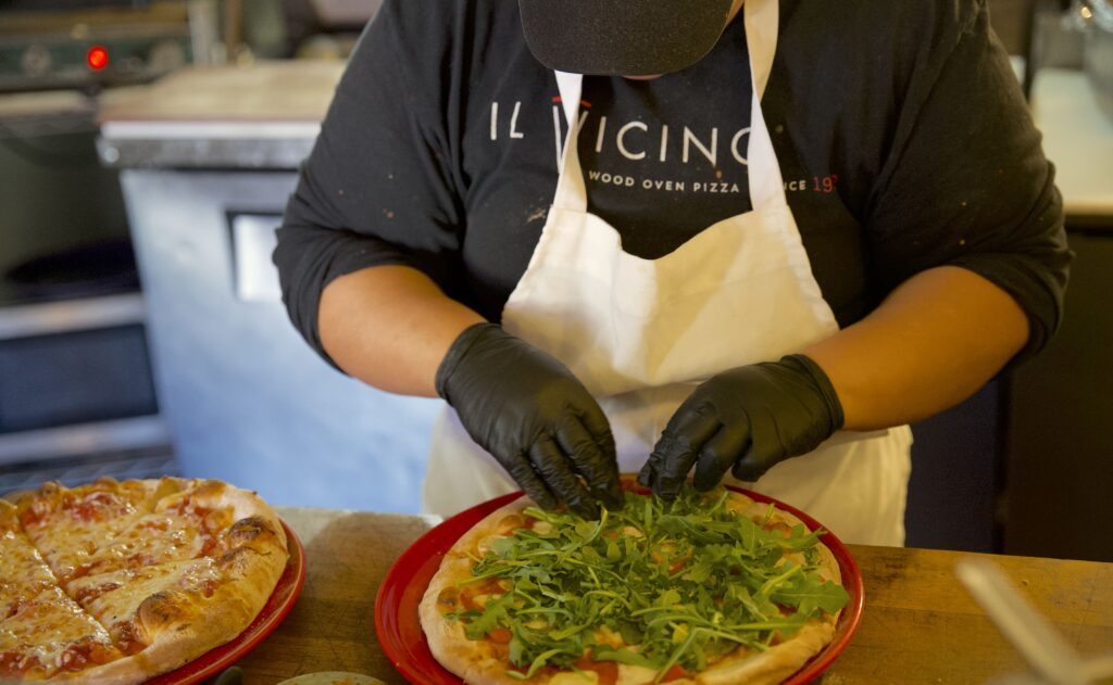 Restaurant staff preparing a pizza in the kitchen