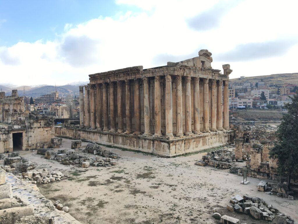 Big Roman style temple with a backdrop of houses.