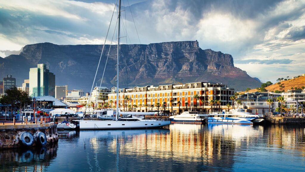 Colourful buildings in a harbour with a big flat mountain in the background