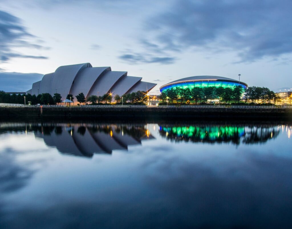 Big buildings near the river in shell like structures.