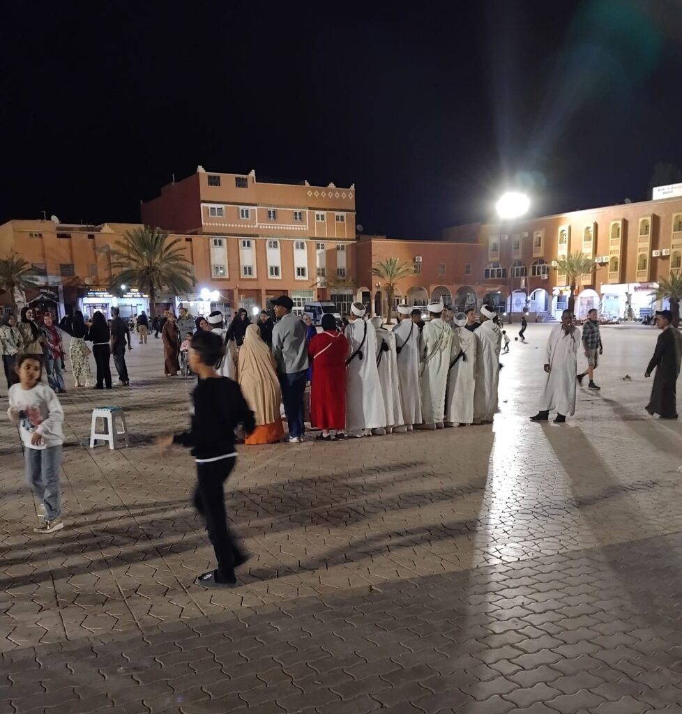 Group of people in a square at night.