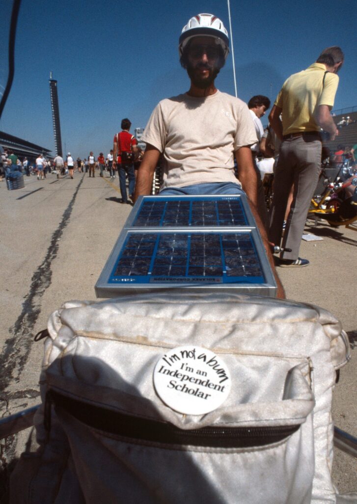 Man on bike with solar panels and bag in front