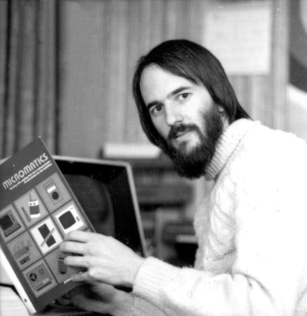 Black and white photo of man reading a book.
