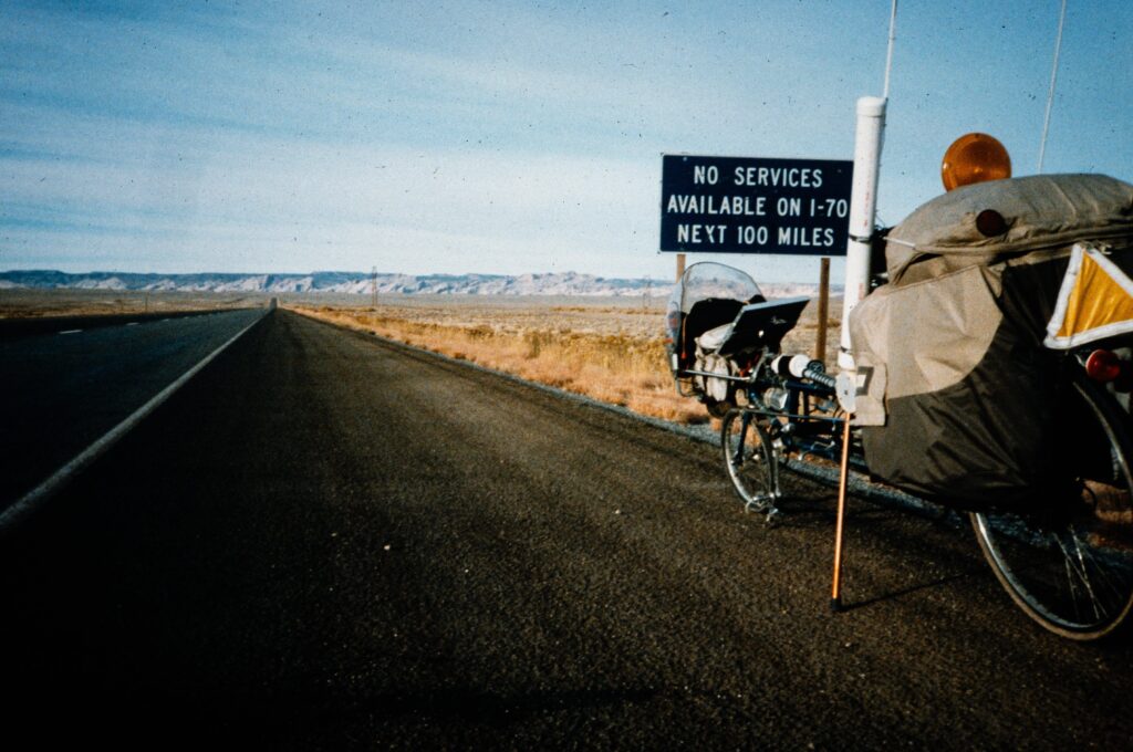 Specially constructed bike on the side of a long straight road.