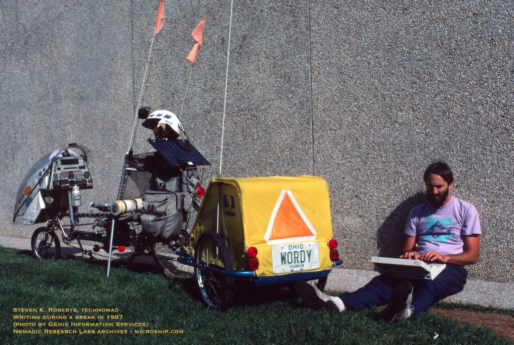 Man leaning against a wall with a specially constructed bike next to him.