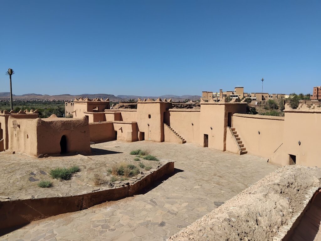 Mud built kasbah under a clear blue sky.