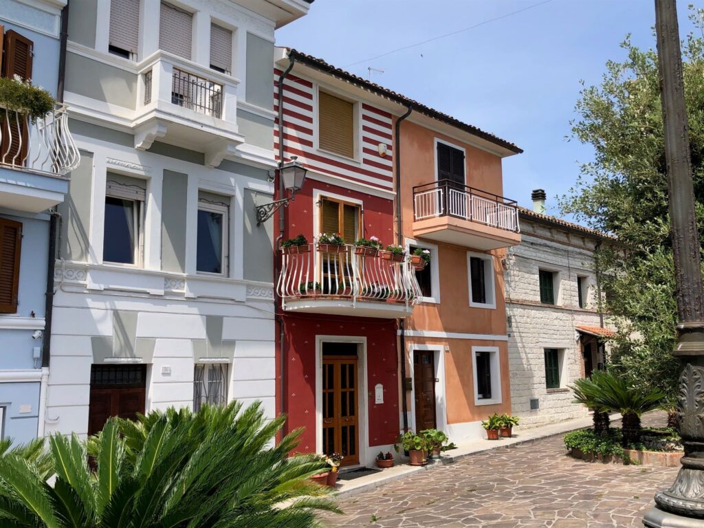 Row of colourful houses with greenery on the street